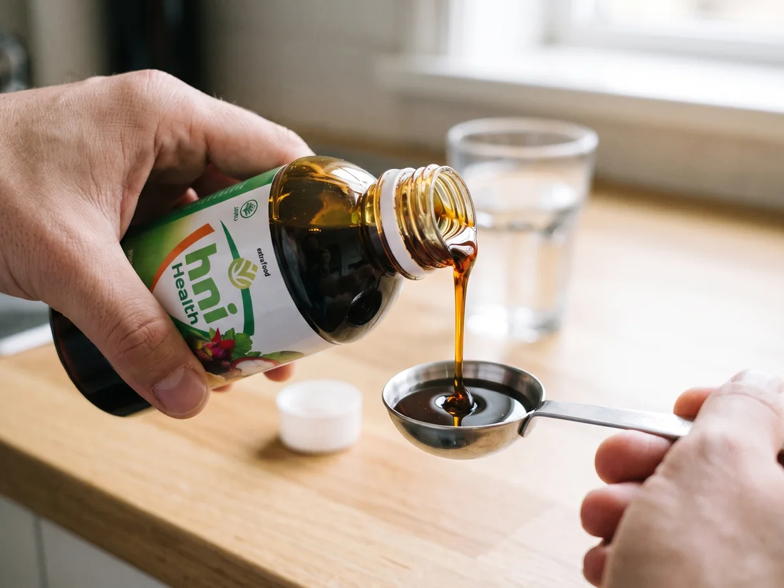 Menuang HNI Health dari botol ke sendok